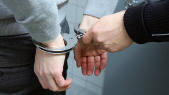 Stock image of hands with handcuffs on them 