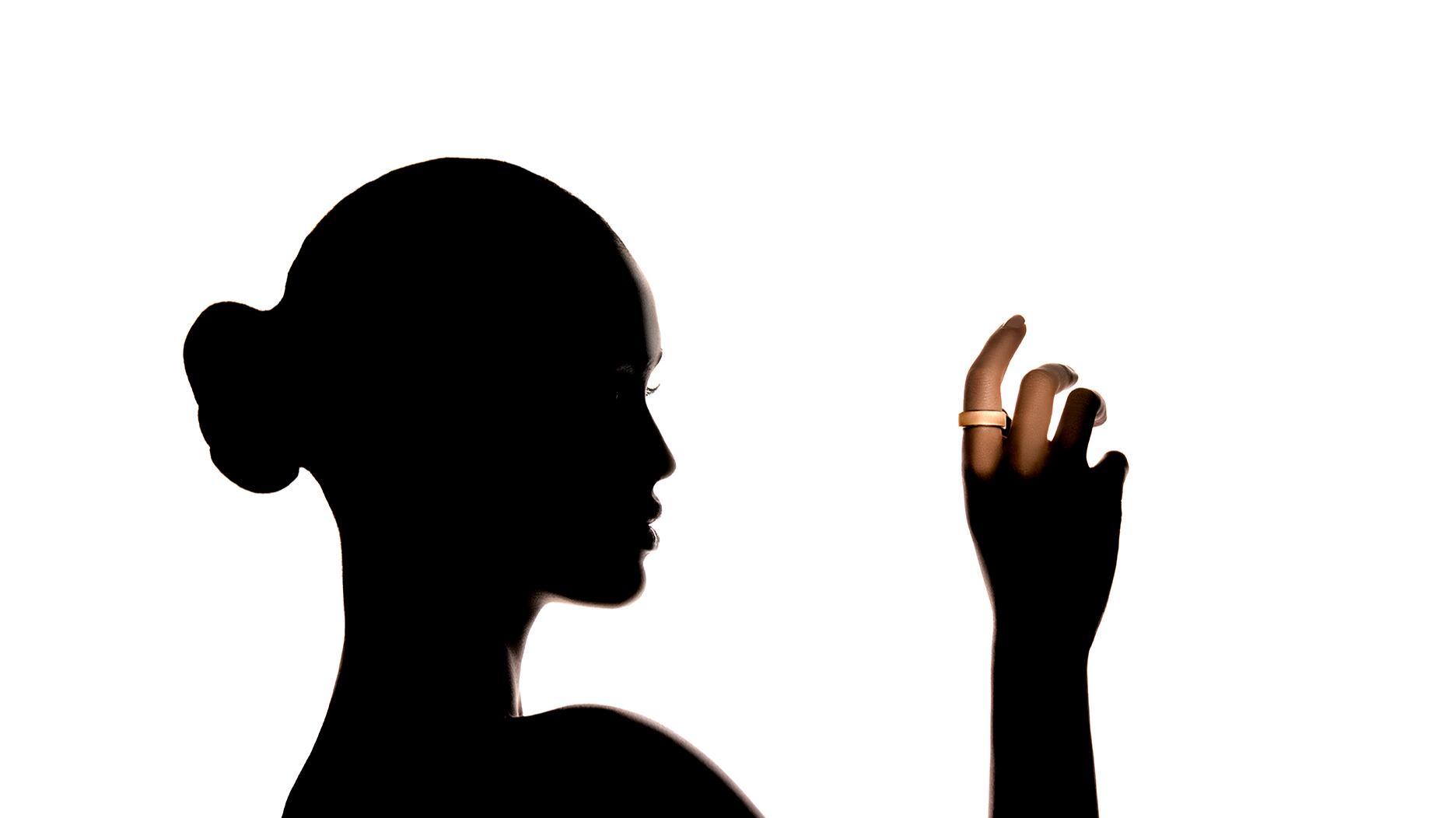 Wearables company Ultrahuman debuted a new line of 18-karat gold and platinum smart rings. Woman’s silhouette with smart ring on finger