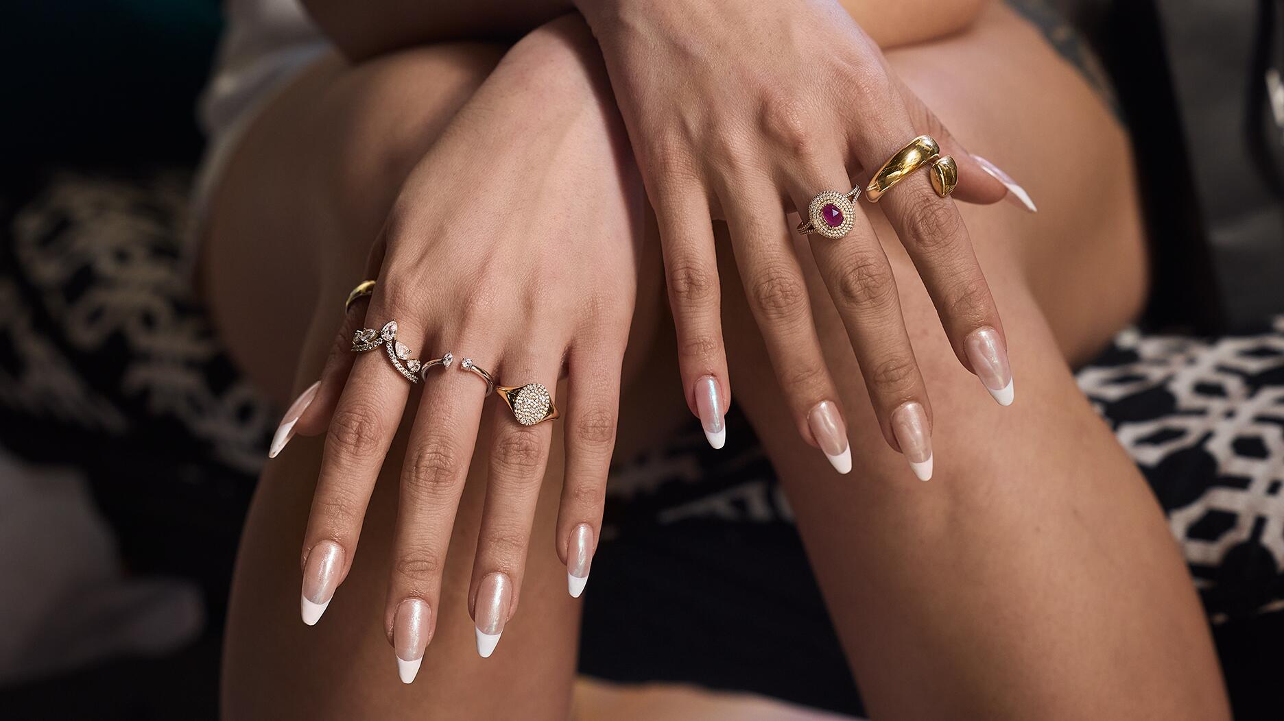 A selection of rings available at Signet-owned banner Kay Jewelers. Signet Jewelers lowered its fourth-quarter guidance following lackluster holiday sales. Woman wearing rings on both hands