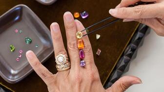 Jewelry designer Lauren Harwell Godfrey looking at colored gemstones