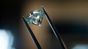 After taking a $1.6 billion impairment charge on De Beers Group last year, parent company Anglo American has written down the value of the diamond miner and marketer by another $2.9 billion. The move comes amid a challenging time for De Beers and the natural diamond industry. (©De Beers Group/Photo credit: Ben Perry @Armoury Films) A polished diamond in tweezers